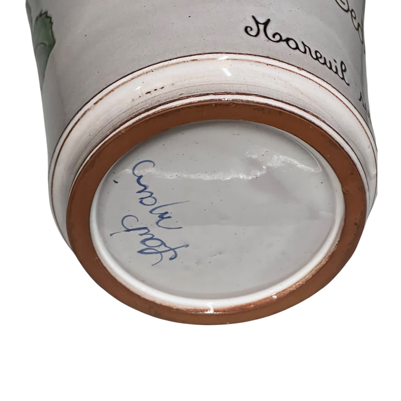 Close-up of a ceramic vase with 'fait mainy' text on a white background
