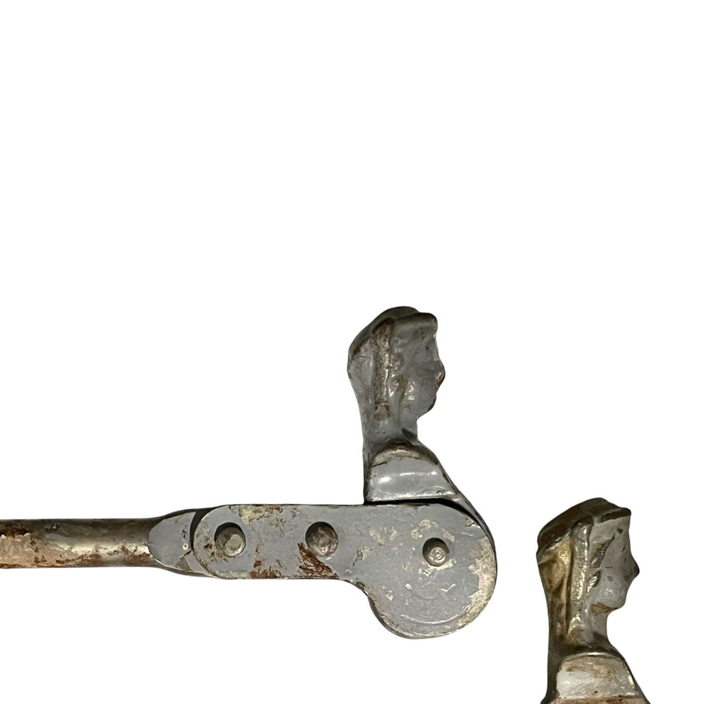 Close up of two rusty metal Belgian ladies shutter dogs on a white background