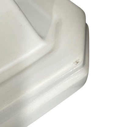 Close-up of a white ceramic shelf corner on a white background