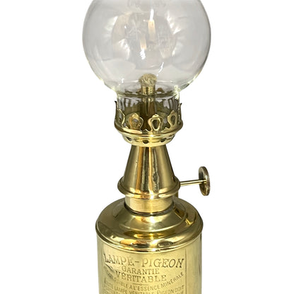 Vintage-style brass lamp with clear glass globe on a white background