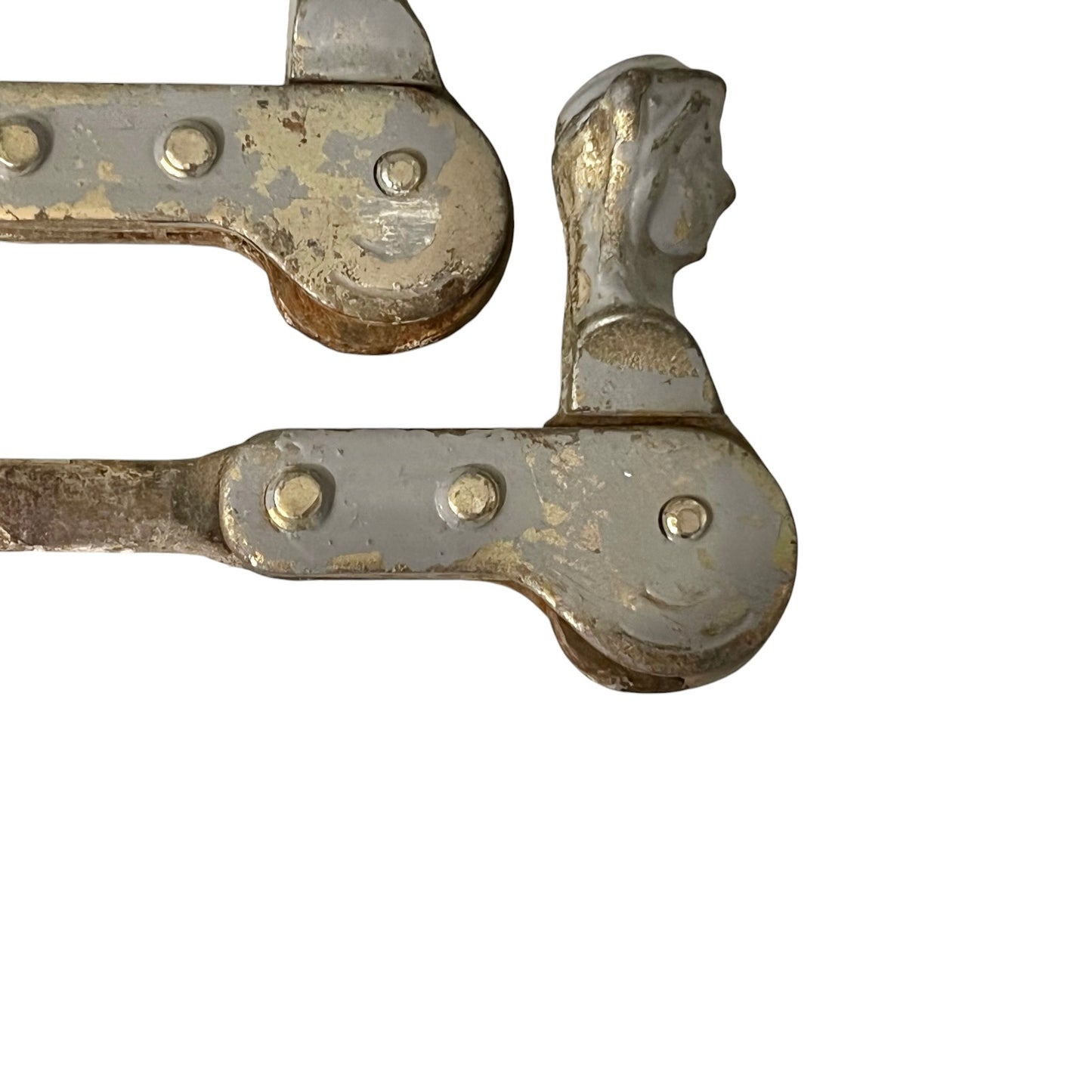 Close up of two rusty metal Belgian ladies shutter dogs on a white background