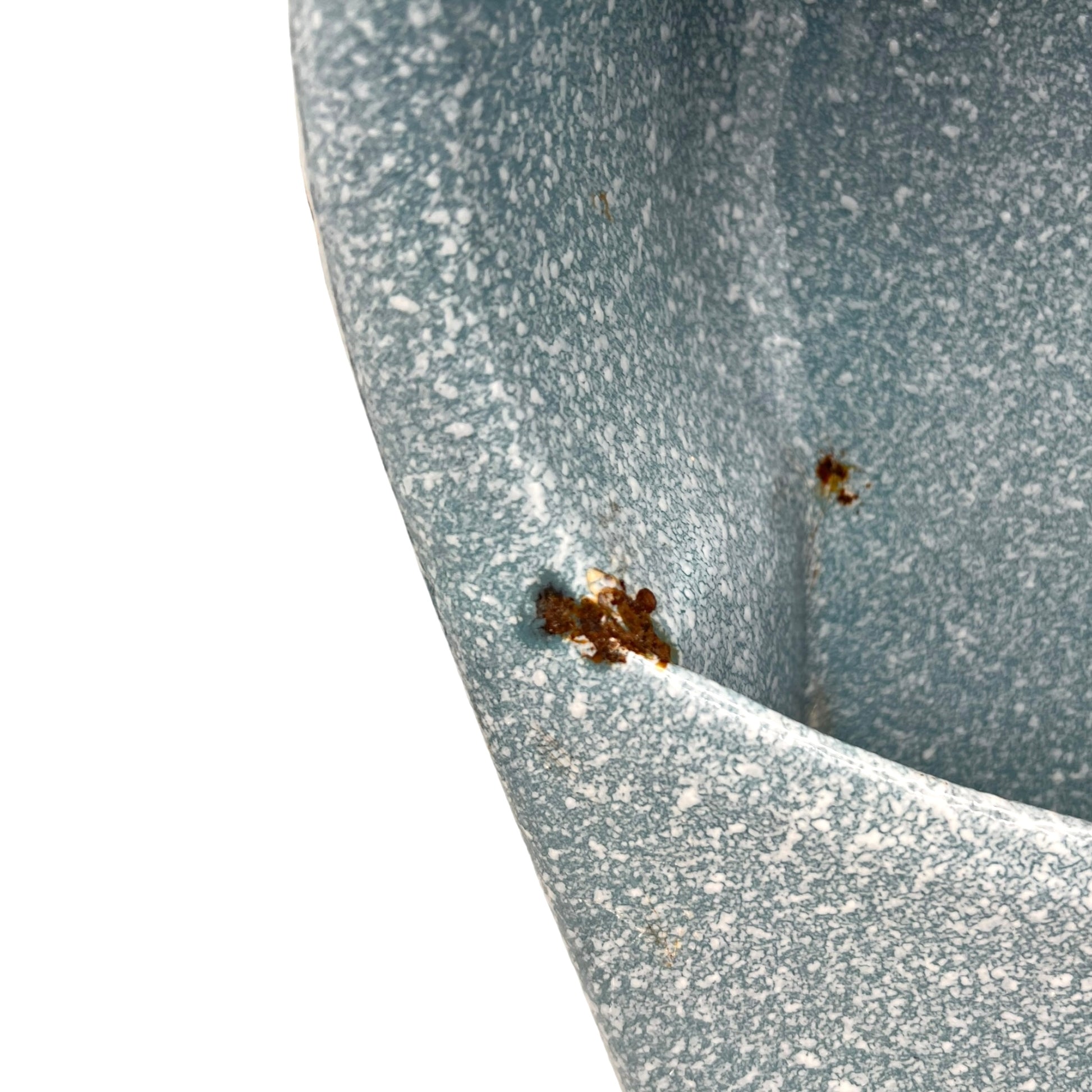 Close-up of wear and tear on a blue metal planter on a white background