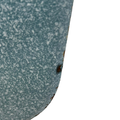 Close-up of wear and tear on a blue metal planter on a white background
