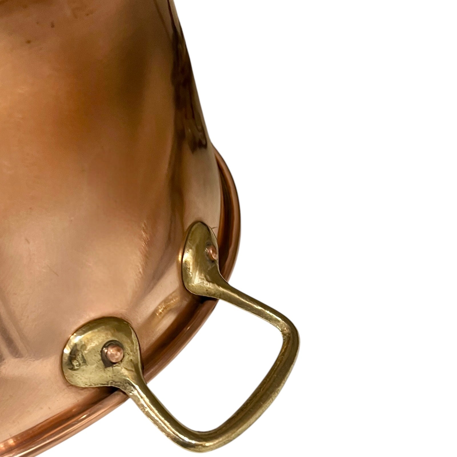 Close-up of a copper pan with brass handle on a white background