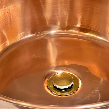 Close-up of a copper sink with a drain