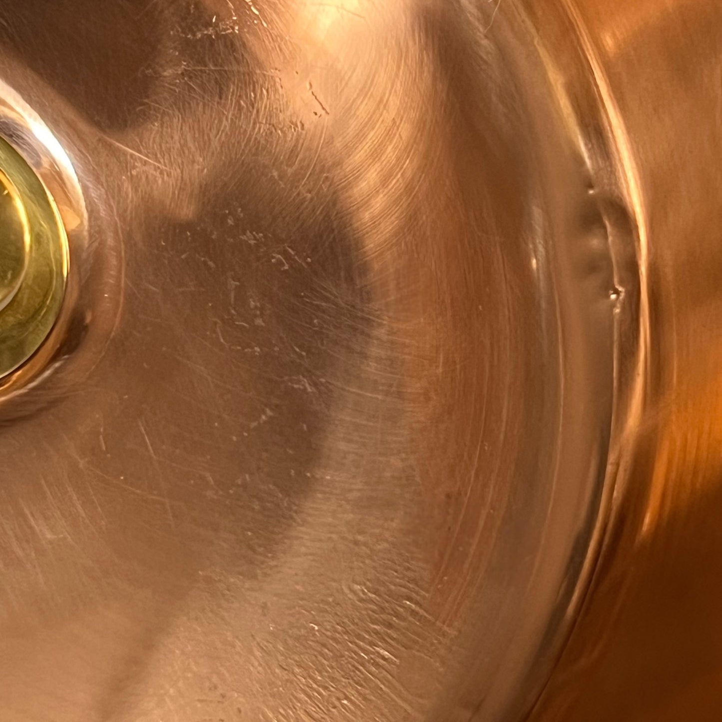 Close-up of a copper sink with a circular metallic object.