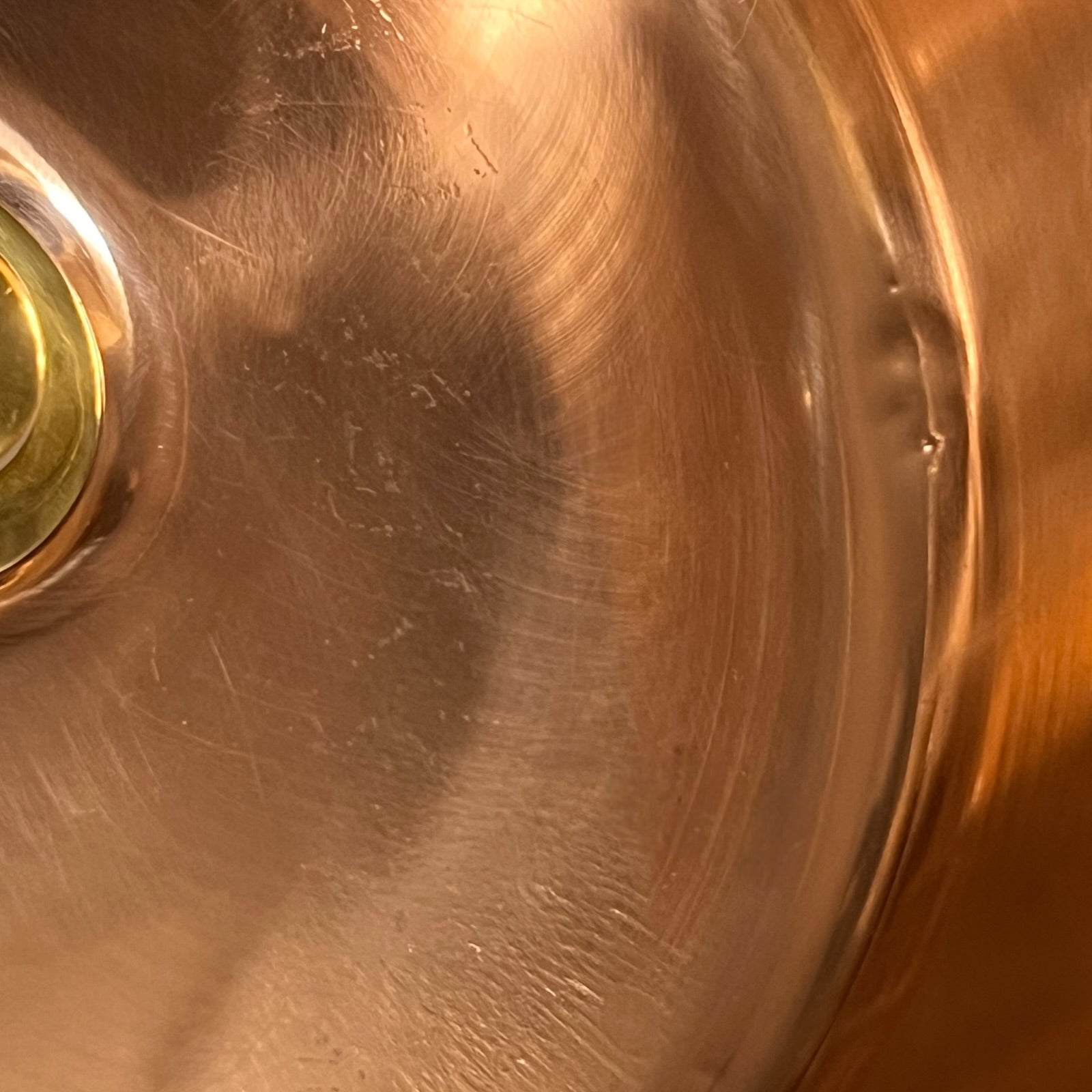 Close-up of a copper sink with a circular metallic object.