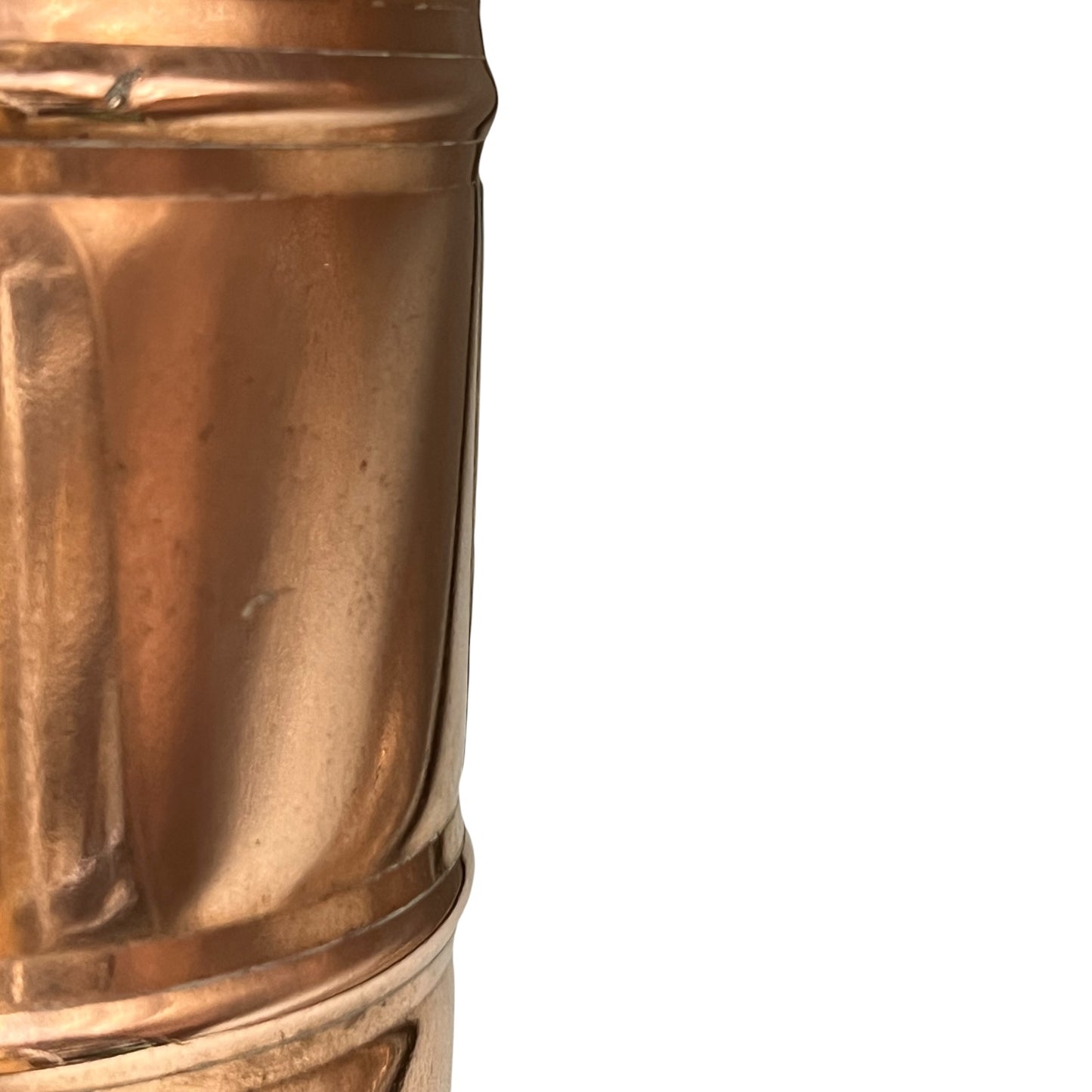 Close-up of a brass or copper cylindrical object with a textured surface on a white background