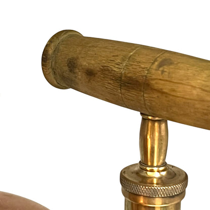Close-up of a wooden handle with brass fitting on a white background