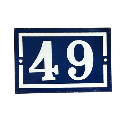 A vintage French enamel blue and white house number 49 displayed against the background.