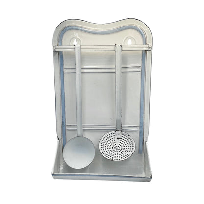 A vintage-style metal kitchen utensil rack with a ladle and a strainer hanging inside a rectangular metal holder on a white background.