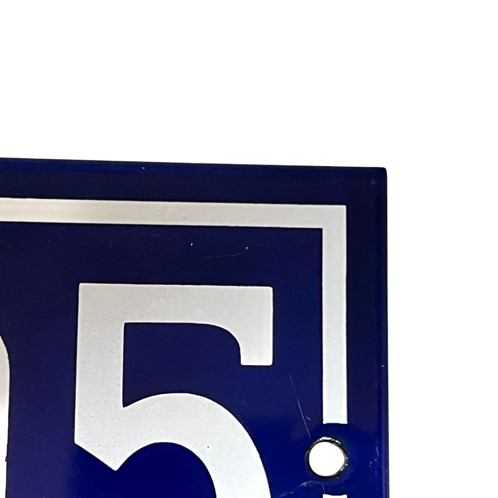 Close-up of a blue sign with the number '195' on a white background