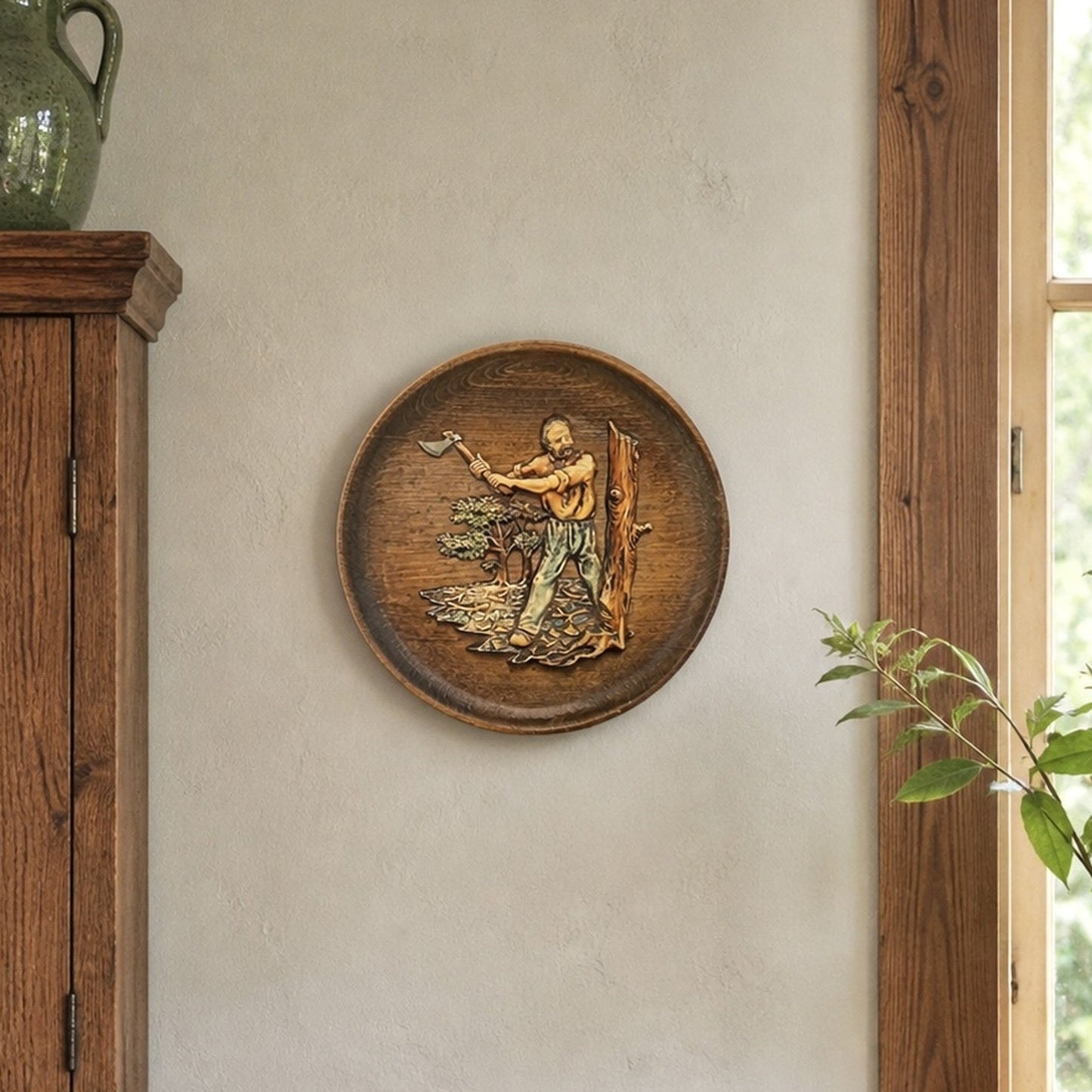 Vintage French wooden wall plaque with raised woodsman scene displayed on a rustic kitchen wall
