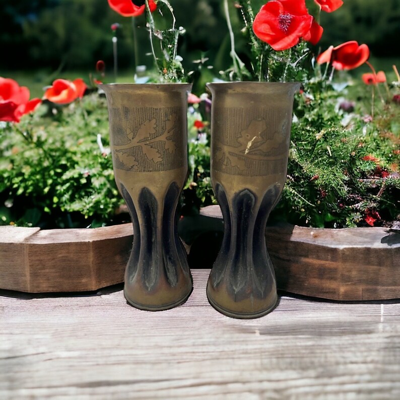 image pair of WW1 trench art vases on a table in a garden with poppies