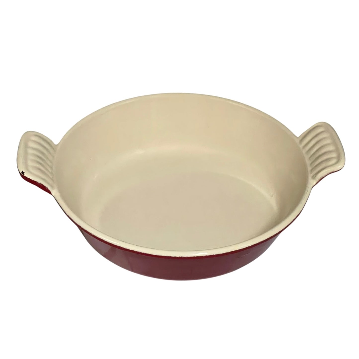 A round ceramic baking dish with a cream-colored interior and a dark red exterior, featuring two ribbed side handles.