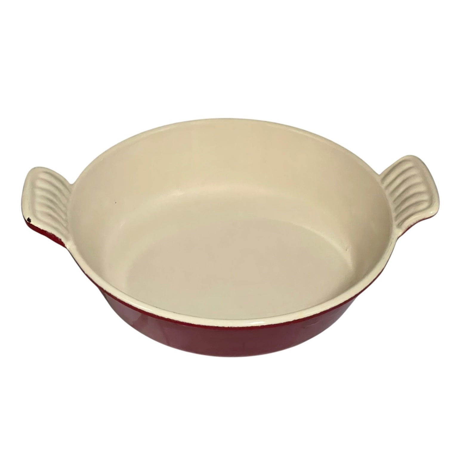 A round ceramic baking dish with a cream-colored interior and a dark red exterior, featuring two ribbed side handles.
