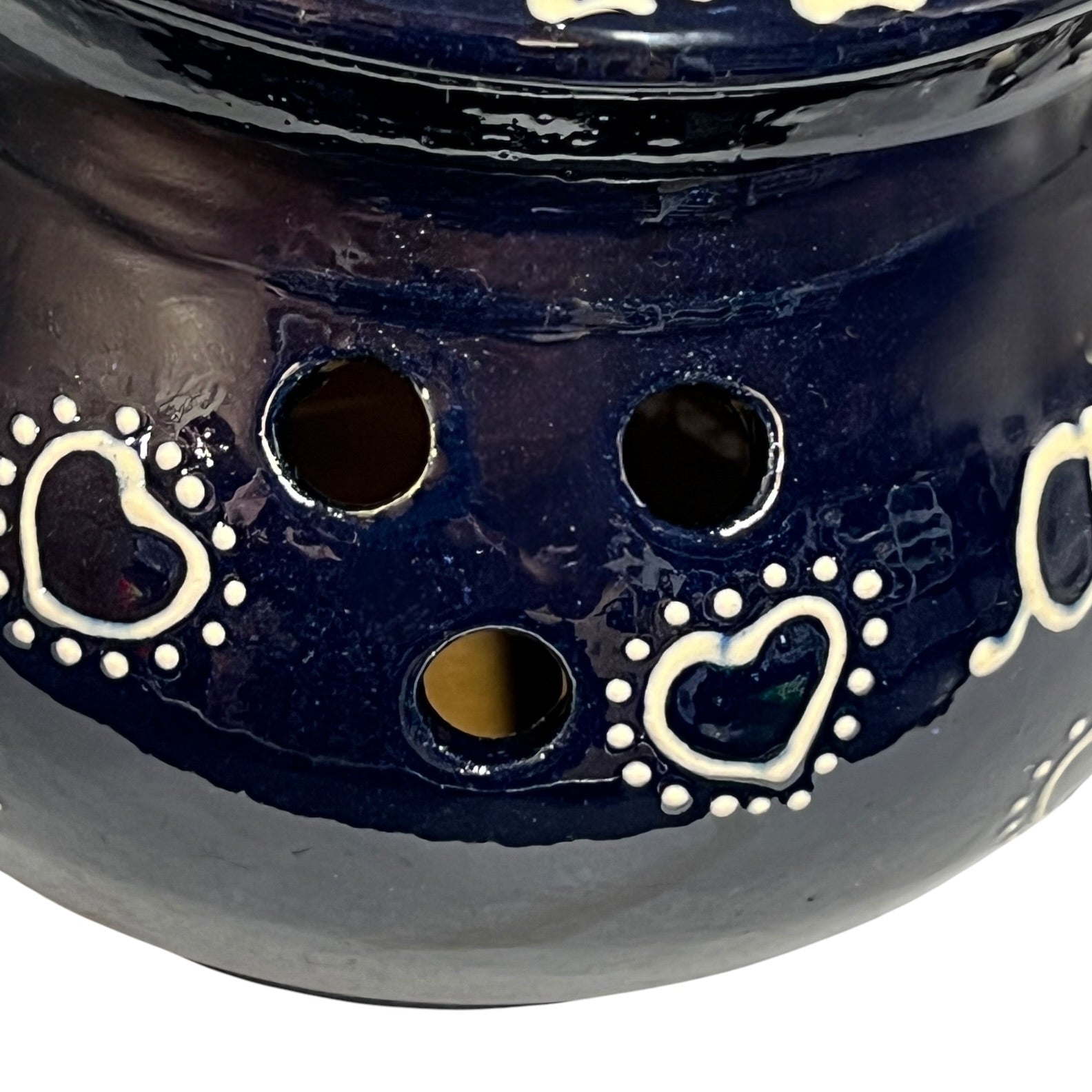 Navy blue ceramic jar with heart designs on a white background