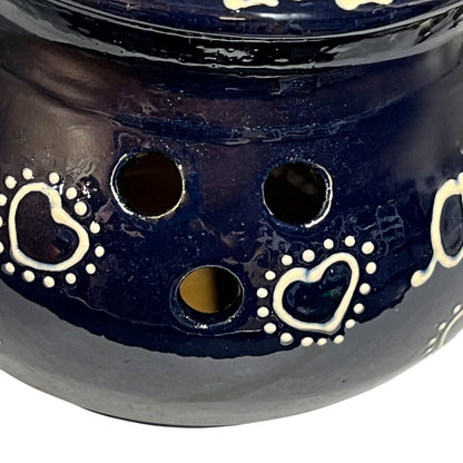 Navy blue ceramic jar with heart designs on a white background