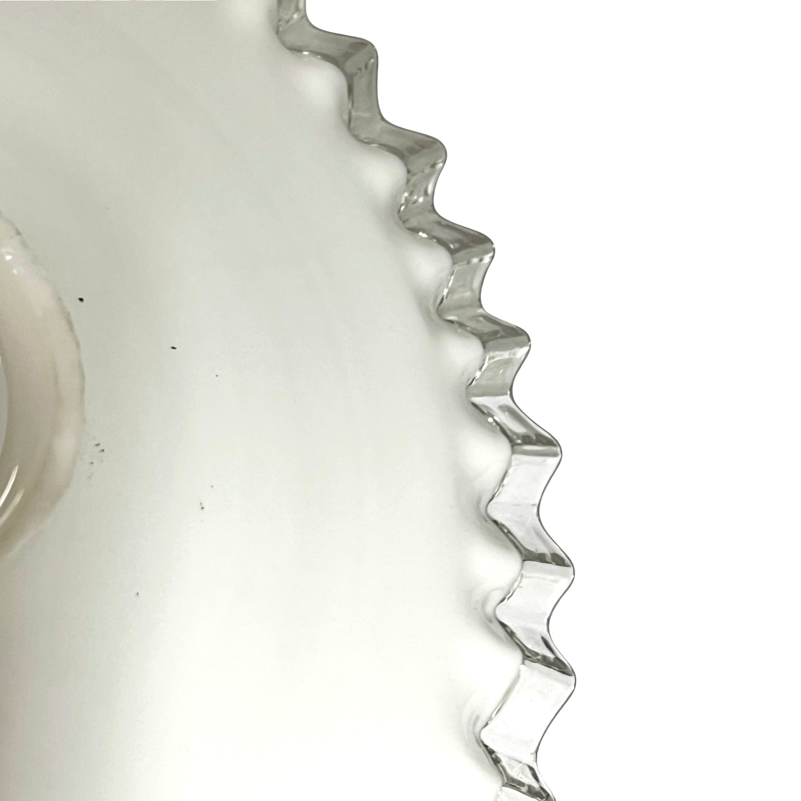 close up of clear rim on French vintage milk glass pendant lampshade on a white background 