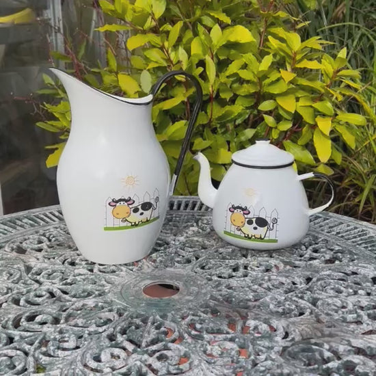 Video of French enamel pitcher jug and matching teapot with a cow design on the front