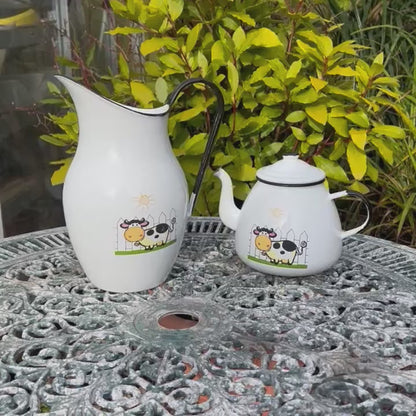 Video of French enamel pitcher jug and matching teapot with a cow design on the front