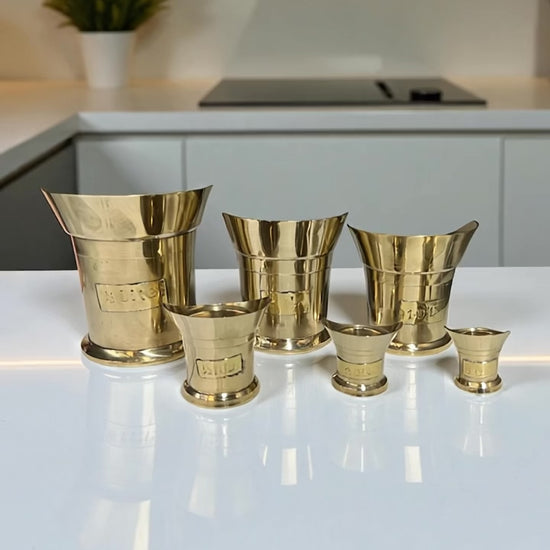 video of a set of 6 brass measuring cups on a kitchen counter top