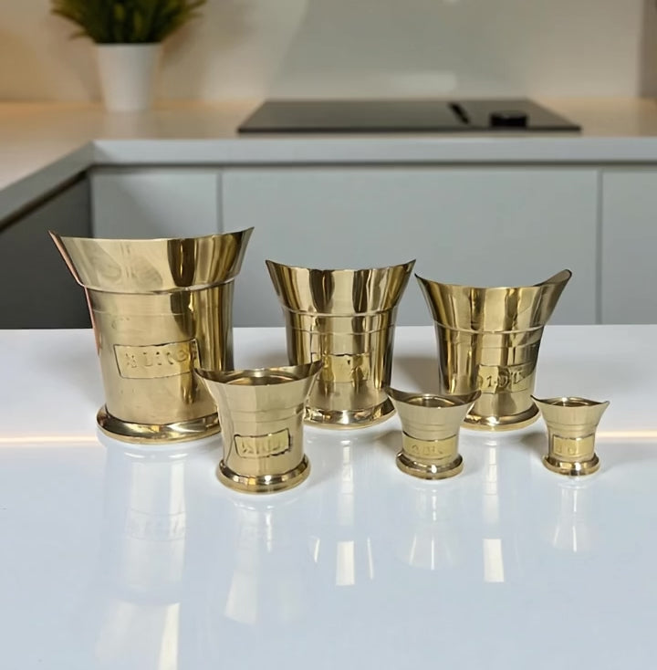 video of a set of 6 brass measuring cups on a kitchen counter top