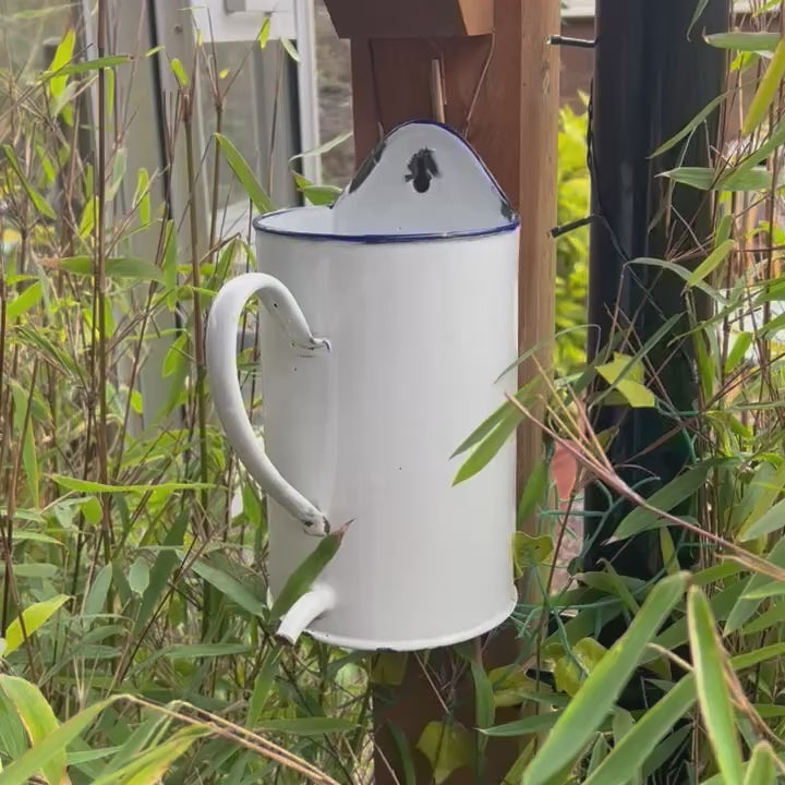 Video of a French enamel planter on a wooden post in a garden