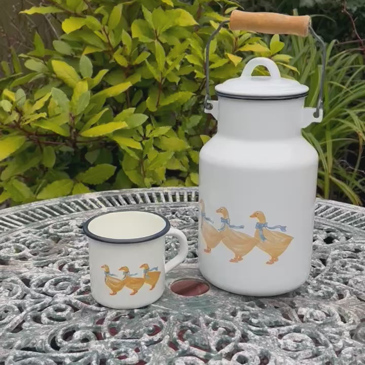 Video of a white enamel milk churn and mug with duck design on a garden table
