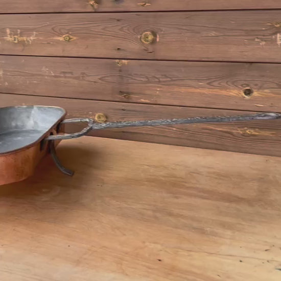 Video of Antique French copper roasting pan with a long handle on a white background