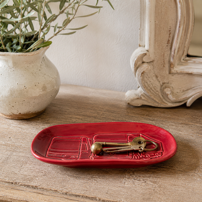 Vintage Renault ceramic trinket tray in deep red glaze with embossed Renault truck design, styled on a rustic wooden hallway table holding keys, beside a French country mirror and ceramic vase with greenery. Ideal as a key dish, catchall tray or automobilia display piece.