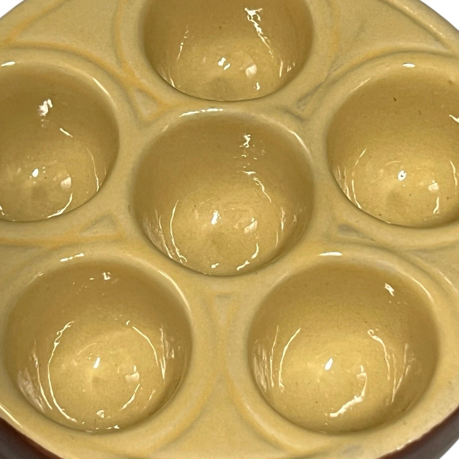 Close up of a  French brown and cream ceramic escargots dish or plate  with 6 holes on a white background 