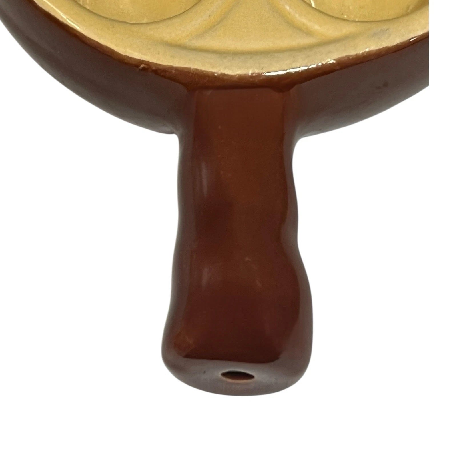 Close up of a French brown and cream ceramic escargots dish or plate handle with 6 holes on a white background 