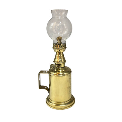Brass oil lamp with clear glass shade on a white background