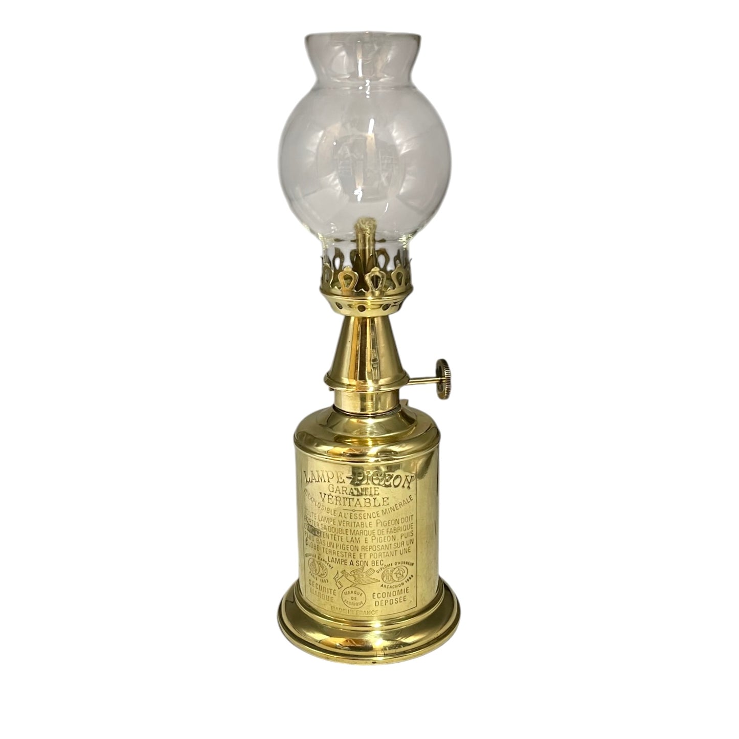 Brass oil lamp with clear glass shade on a white background