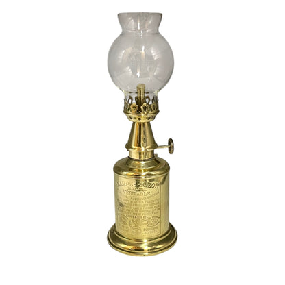 Brass oil lamp with clear glass shade on a white background