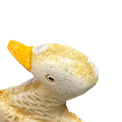 Close-up of a duck figurine with a yellow beak on a white background