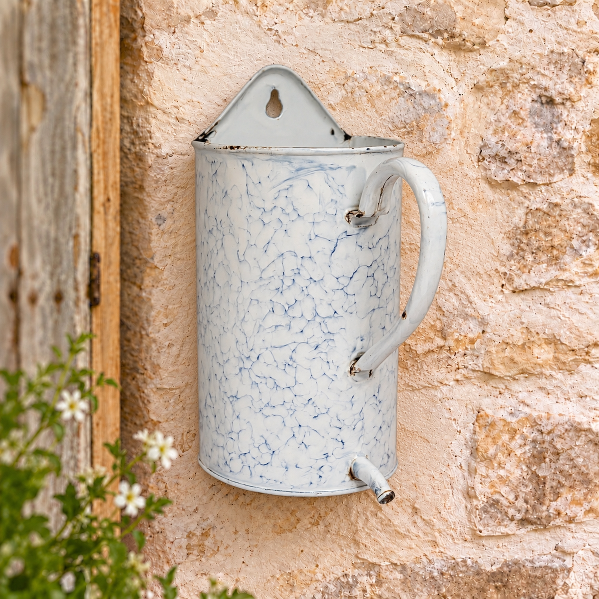 A vintage-style enamel planter with a blue crackle pattern on a white background, mounted on a rustic stone wall.