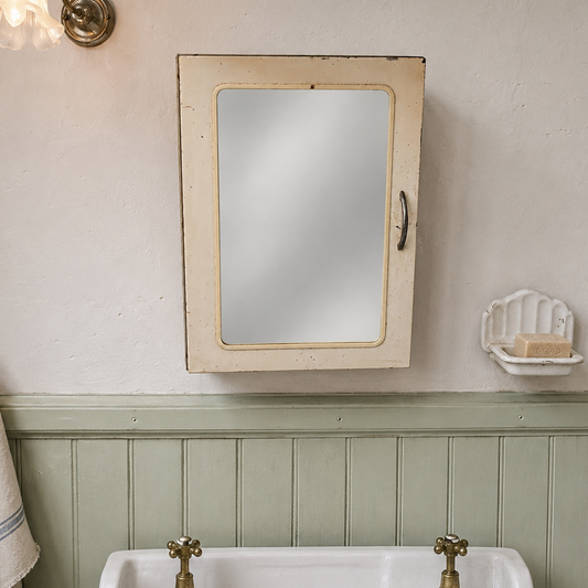 Bathroom with a French shabby chic vintage mirrored cabinet above a sink with brass fixtures.
