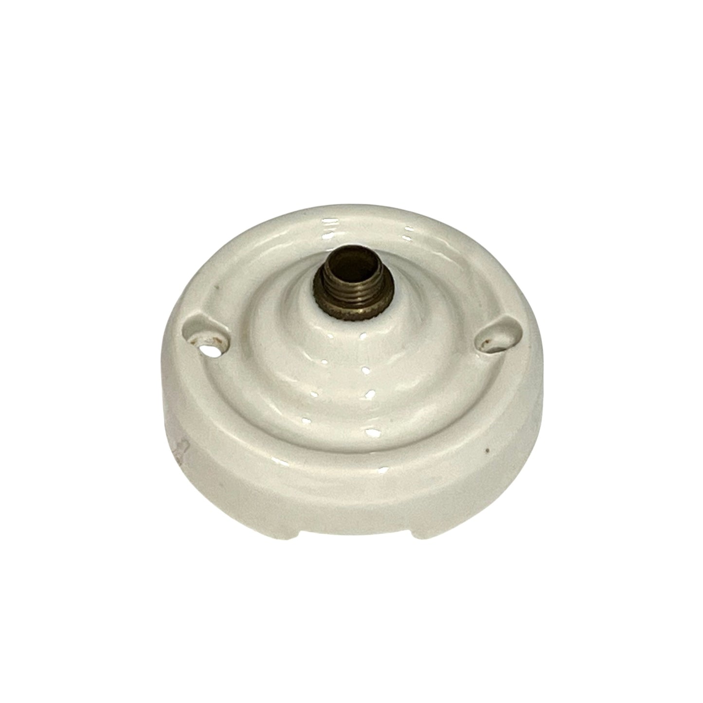 A vintage white porcelain ceiling rose with a brass screw connector on top, isolated on a white background.