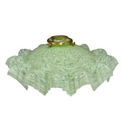 A vintage light green textured glass lamp shade with a flared, ruffled edge and a brass metal fixture at the top, shown against a plain white background.
