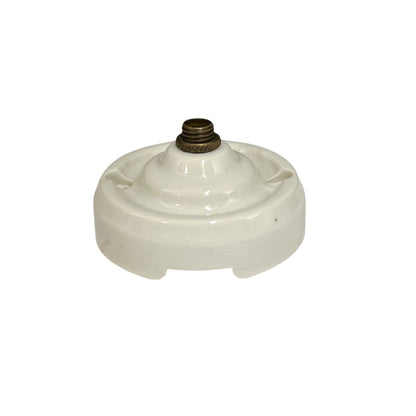 A vintage white porcelain ceiling rose with a brass screw connector on top, isolated on a white background.