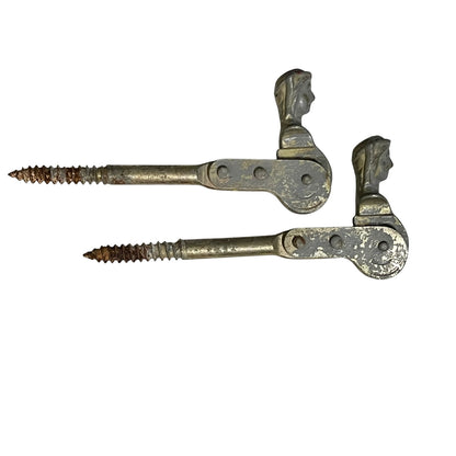 Two rusty metal Belgian ladies shutter dogs on a white background